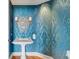 Powder room featuring blue patterned wallpaper, pedestal sink, decorative mirror and wood flooring at 3344 Peachtree Ne Rd # 3504, Atlanta, GA 30326