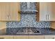 Close-up of modern kitchen features including the stove, countertop and backsplash at 3344 Peachtree Ne Rd # 3504, Atlanta, GA 30326
