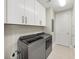 Laundry room featuring new gray front load washer and dryer and white storage cabinets at 3344 Peachtree Ne Rd # 3504, Atlanta, GA 30326