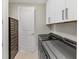 Laundry room featuring new gray front load washer and dryer, white storage cabinets, and wine cooler at 3344 Peachtree Ne Rd # 3504, Atlanta, GA 30326