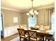 Traditional dining room featuring crown molding, wainscotting, an elegant chandelier, and a wood table for six at 753 Summer Ridge Dr, Villa Rica, GA 30180