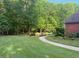 Expansive lawn, mature trees and path leading to the rear yard, offering space for recreation and relaxation at 753 Summer Ridge Dr, Villa Rica, GA 30180
