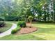 Lush backyard with a sidewalk, vibrant plants, and mature trees, creating a peaceful outdoor setting at 753 Summer Ridge Dr, Villa Rica, GA 30180