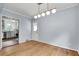 Bright dining area featuring hardwood floors and a modern light fixture, flowing into the kitchen at 1131 Forrest Blvd, Decatur, GA 30030