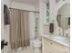 Well-lit bathroom featuring marble countertop, hexagon tile floor, and shower with tan and white striped curtain at 174 Pearl Se St, Atlanta, GA 30316
