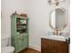 Traditional powder room featuring a decorative mirror, marble countertop, and wood cabinetry at 174 Pearl Se St, Atlanta, GA 30316