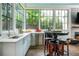 Sunroom bar area featuring large windows, bar seating, sink, and stainless steel refrigerator at 174 Pearl Se St, Atlanta, GA 30316