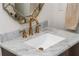 Close up of a powder room vanity featuring a decorative mirror and marble countertop at 174 Pearl Se St, Atlanta, GA 30316