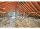 Unfinished attic area featuring wood beams, insulation and single window providing natural light at 3358 Lake Dr, Lawrenceville, GA 30044