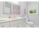 Clean, bright bathroom with white vanity, sink, mirror, and a window with natural light at 3358 Lake Dr, Lawrenceville, GA 30044