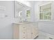 Bathroom featuring a white vanity with marble top, a large mirror, a window and neutral walls at 3358 Lake Dr, Lawrenceville, GA 30044