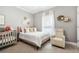 Comfortable bedroom with crib, large bed, beige chair, and window letting in natural light at 3358 Lake Dr, Lawrenceville, GA 30044