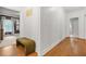 Bright hallway featuring hardwood floors, white trim, bench and view into the bedroom at 3358 Lake Dr, Lawrenceville, GA 30044