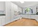 Bright kitchen with white cabinets, matching appliances, and wood floors at 3358 Lake Dr, Lawrenceville, GA 30044
