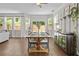 Well-lit dining area featuring hardwood floors and a large window with sliding door access to the backyard at 4020 New Salem Ct, Cumming, GA 30040