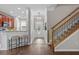 Inviting foyer with hardwood flooring, a staircase with wood banister, and a view into the adjacent kitchen and dining areas at 4020 New Salem Ct, Cumming, GA 30040