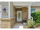 Charming front entrance with brick accents, a decorative door, and lush landscaping at 4020 New Salem Ct, Cumming, GA 30040