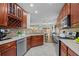 Well-lit kitchen featuring wooden cabinets, stainless steel appliances, and an open view to an adjacent dining area at 4020 New Salem Ct, Cumming, GA 30040