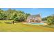 Aerial view of the backyard with a swimming pool, grassy area, and mature trees at 1504 Terminal Ct, Mcdonough, GA 30252