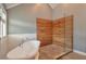Well-lit bathroom with soaking tub and glass-enclosed shower featuring wood-look tiling at 1504 Terminal Ct, Mcdonough, GA 30252