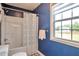 A blue bathroom featuring a shower with a window at 1504 Terminal Ct, Mcdonough, GA 30252
