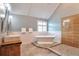 Bright bathroom with soaking tub, double sinks, a glass shower, and vaulted ceilings at 1504 Terminal Ct, Mcdonough, GA 30252