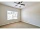 Neutral bedroom with a ceiling fan and a large window overlooking the yard at 1504 Terminal Ct, Mcdonough, GA 30252