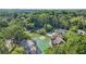 Aerial view of community featuring apartment buildings, lake, tennis court, pool, and dense trees at 305 Mill Pond Se Ct, Smyrna, GA 30082