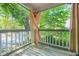 Balcony featuring painted wooden railings, curtains, and wood flooring overlooking tree canopy at 305 Mill Pond Se Ct, Smyrna, GA 30082
