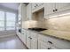Bright kitchen featuring granite countertops, light backsplash, gas cooktop, built in oven and white cabinets at 5210 Davenport Pl, Roswell, GA 30075
