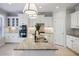 This bright kitchen features white cabinets, stainless steel appliances, granite countertops and a large island with sink at 5210 Davenport Pl, Roswell, GA 30075