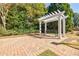 A tranquil outdoor seating area featuring a pergola with a bench on a brick patio at 5210 Davenport Pl, Roswell, GA 30075