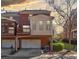 Rear exterior of a brick townhome featuring a garage, balcony, and cozy sunroom at 5210 Davenport Pl, Roswell, GA 30075