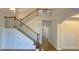 Bright, open entryway showcasing stairs with a light wood banister and dark iron spindles at 6515 Bentley Ridge Dr, Cumming, GA 30040