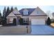 Charming home featuring a brick facade, well-manicured lawn, two-car garage, and inviting curb appeal at 6515 Bentley Ridge Dr, Cumming, GA 30040