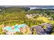 Aerial view of the community pool, clubhouse, and surrounding homes, set amidst a backdrop of a beautiful lake at 200 Glen Wood Place, Canton, GA 30114