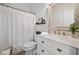 Well-lit bathroom with a white vanity, framed mirror, shelf, and shower with a curtain at 200 Glen Wood Place, Canton, GA 30114