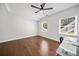 Bright bedroom featuring hardwood floors, a ceiling fan, and large windows with outdoor views at 200 Glen Wood Place, Canton, GA 30114