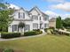 Beautiful two-story home featuring a manicured lawn, elegant landscaping, and a charming walkway at 200 Glen Wood Place, Canton, GA 30114