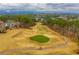 Picturesque view of the golf course with green grass and rolling hills on a partly cloudy day at 200 Glen Wood Place, Canton, GA 30114