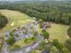 Aerial view showcasing a well-maintained golf course, clubhouse, and parking area surrounded by trees at 200 Glen Wood Place, Canton, GA 30114