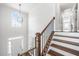 Grand staircase with wood and iron railing, leading to a bright entryway with chandelier and large window at 200 Glen Wood Place, Canton, GA 30114