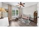 Bright bedroom featuring a ceiling fan, a crib, a stylish rug, and a view of the outdoors through the window at 2653 W Main Nw St, Atlanta, GA 30318