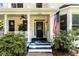 Inviting front porch with blue steps, white railings, and lush green bushes at 2653 W Main Nw St, Atlanta, GA 30318