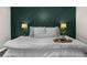 Spacious main bedroom featuring a decorative accent wall with overhead lighting from bedside lamps at 2653 W Main Nw St, Atlanta, GA 30318