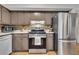 Well-lit kitchen with stainless steel refrigerator and range, tile backsplash, and wooden cabinets at 289 Westland Sw Way, Marietta, GA 30064