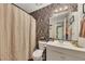 A bathroom featuring a shower with a beige curtain, toilet, vanity, and floral wallpaper creates a relaxing and functional space at 289 Westland Sw Way, Marietta, GA 30064