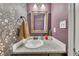 A powder room with floral wallpaper, granite countertop, and a decorative mirror offers stylish convenience at 289 Westland Sw Way, Marietta, GA 30064