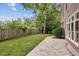 Grassy backyard with brick home, stamped concrete patio, and a wooden fence at 4046 Newhaven Ne Cir, Atlanta, GA 30319