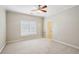Neutral-toned bedroom with carpet, ceiling fan, and a window with blinds, leading into an ensuite bathroom at 4046 Newhaven Ne Cir, Atlanta, GA 30319